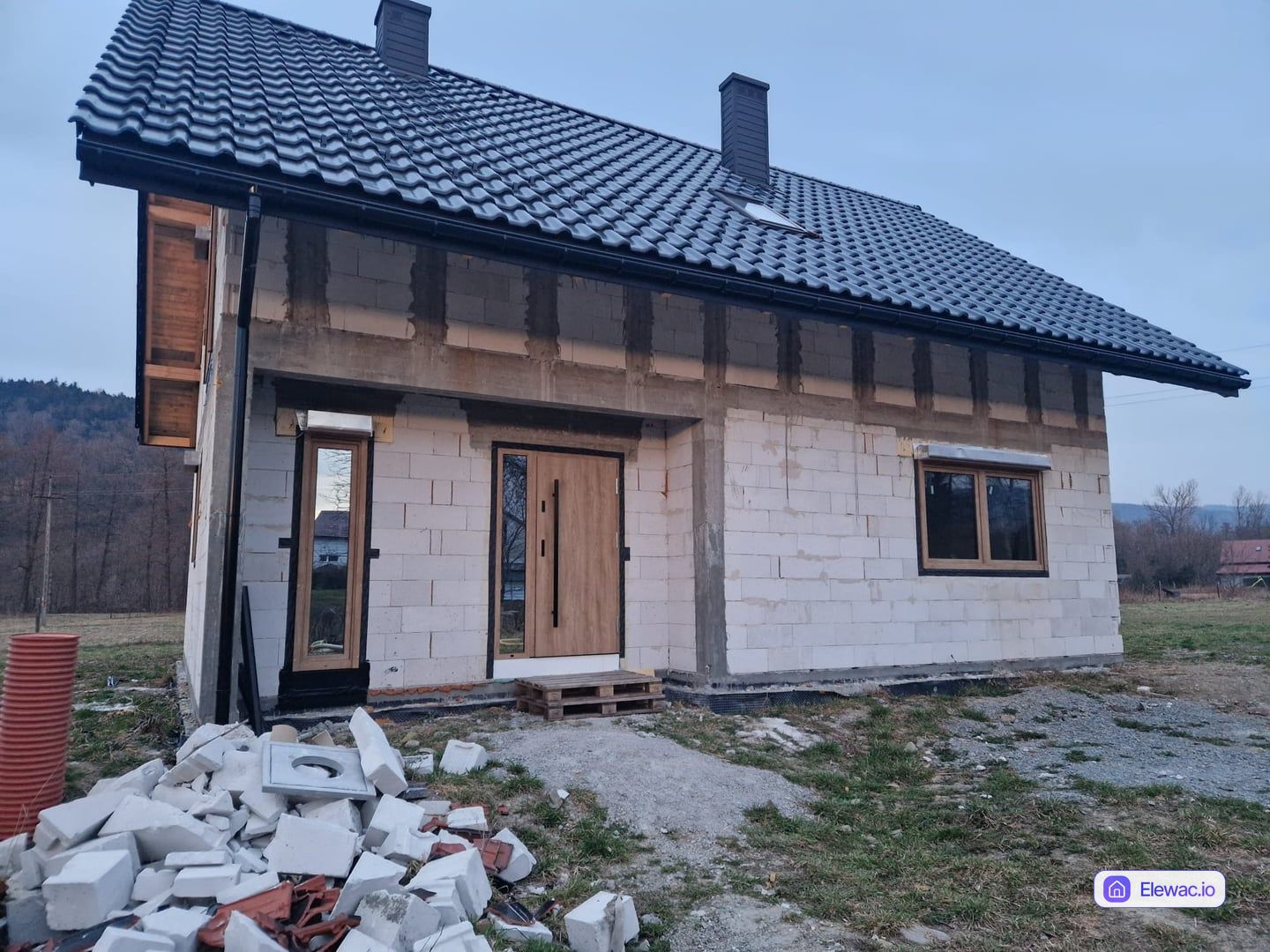 Nowoczesny dom jednorodzinny w stanie surowym z widocznymi bloczkami przed ociepleniem elewacji