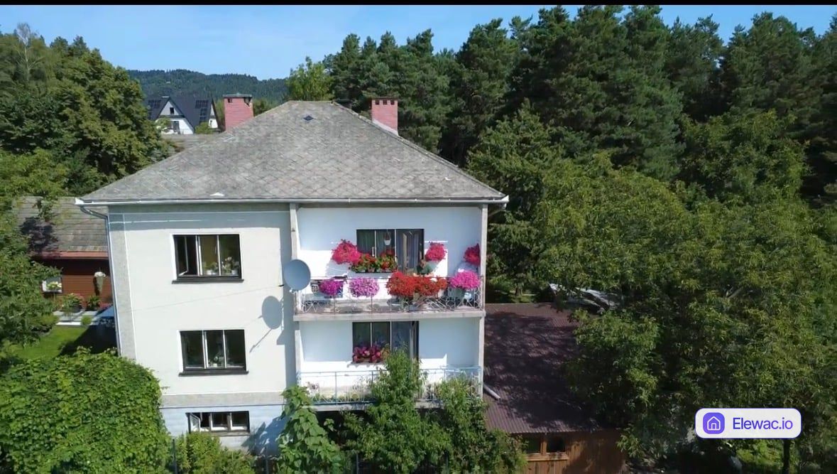 Dom jednorodzinny z lat 80. ze zniszczonym tynkiem i starym dachem przed remontem elewacji